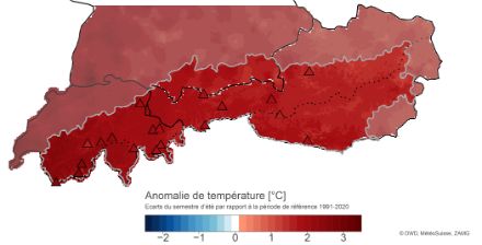 Carte des Alpes centrales et orientales avec un dégradé de couleurs de l'écart par rapport la norme 1991-2020 de la température moyenne de l'air en °C. En plus des données de la grille, certaines stations d'altitude (>1500 m) sont représentées.