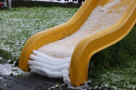 Une fine couche de neige humide et lourde repose sur un toboggan et se replie. Ce genre de spectacle se produit souvent au printemps.