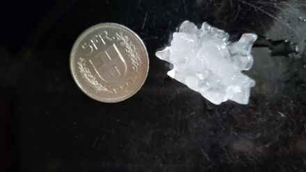 Photo d'un grêlon observé le mercredi 12 juillet 2023 à Langnau im Emmental (BE) à côté d'une pièce de 5 francs.