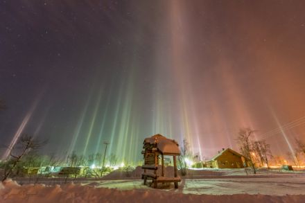 Sur cette image prise à Kilpisjärvi en Finlande, un poudrin de neige sous un ciel étoilé provoque des colonnes de lumière juste au-dessus des éclairages nocturnes