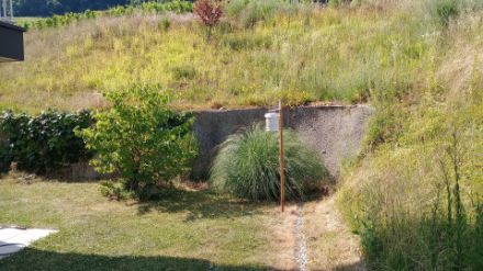 Idéalement, l’abri doit être installé au soleil à une hauteur de 1,5 à 2 m sur un terrain herbeux dégagé. Cela n’est toutefois pas toujours possible, comme sur cette photo où l’abri est à proximité d’un mur et de buissons.