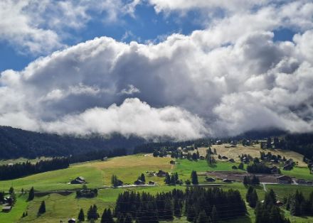 Nuages accrochés au relief, grand soleil au-dessus