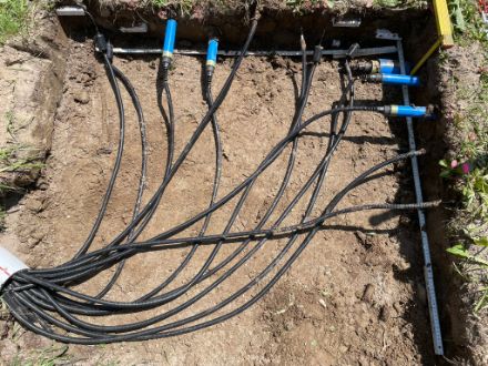 Capteurs installés avec câbles dans une tranchée de terre.