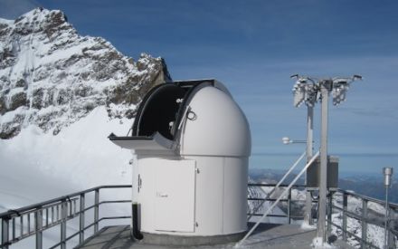 La photographie présente la coupole astronomique sur le toit de la station de recherche du Sphinx. À sa droite, une installation de mesure haute de trois mètres et dotée de divers radiomètres sert à mesurer le rayonnement UV, solaire global et infrarouge thermique.