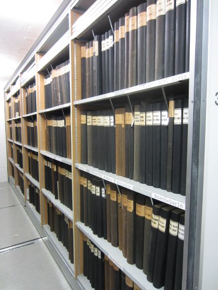 Livres noirs avec titres comprenant les descriptions climatologiques originales à MétéoSuisse rangés sur des étagères avant leur transfert aux Archives fédérales