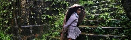 Une villageoise se protège de la pluie avec des « knups » tissés en bambou.