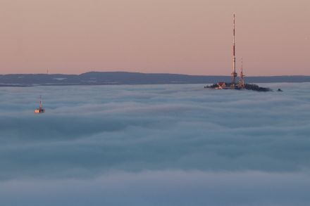 Photo d’une mer de brouillard d’où émergent des sommets isolés.