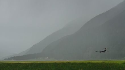 Photo de la piste d'atterrissage de l'aéroport de Samedan. Le paysage à l'arrière-plan n'est pas très visible en raison de la forte pluie.