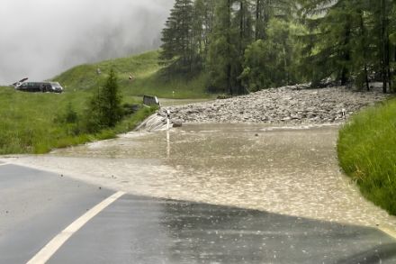 Une route de montagne est inondée après de fortes pluies. L'eau recouvre la chaussée et la rend impraticable.