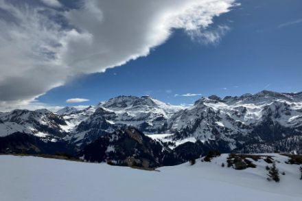 Paysage de montagne avec de la neige, un ciel bleu et des nuages de foehn