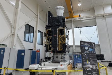Le satellite Meteosat Third Generation Sounder (MTG-S) se trouve dans une salle blanche pendant la phase d'intégration ou de test. Il est installé sur une plate-forme de transport, entouré de barrières de sécurité et de documentation.