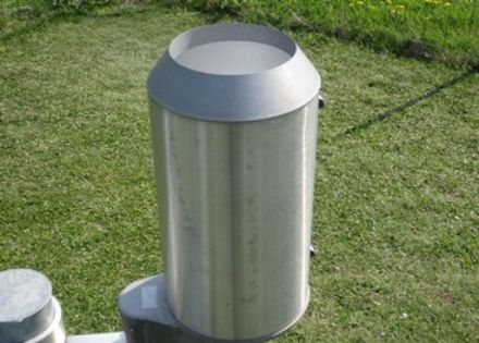 Récipient collecteur cylindrique en métal, ouvert par le haut.